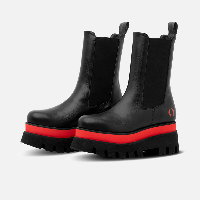 Dos botas de piel con suela alta negras y rojas con el logo de mikakus en el talón